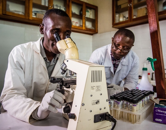 two lab techs looking through a telescope