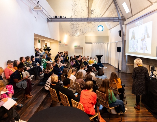 A group of people sitting down on steps and listening to a seminar